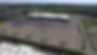 Front, aerial view of large Walmart facility and adjacent parking lot