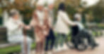 Group of elder friends using different assistance devices while spending time outdoors.