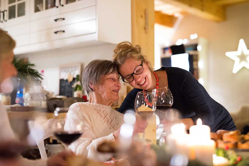 Multi-generational family celebrating Christmas dinner together around the table.