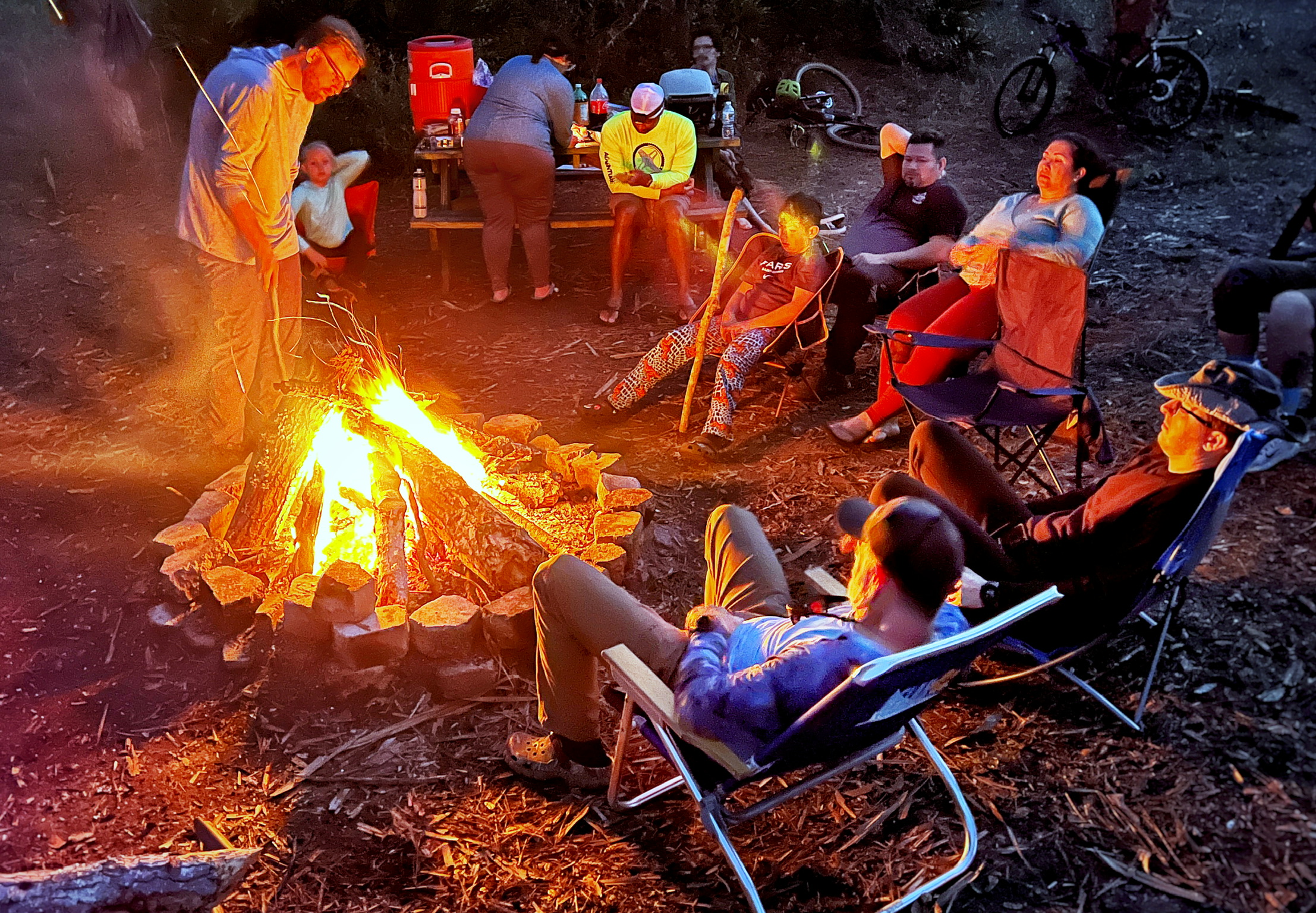 Gathering around a campfire beneath the evening sky