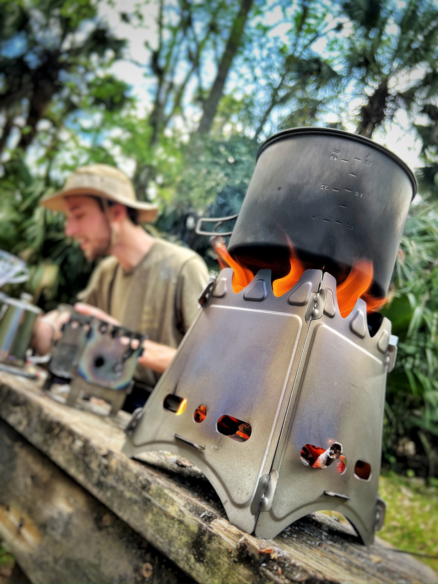 Preparing camp coffee over an open flame in the woods