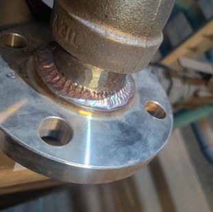 Detalhe de solda em flange de tubulação, Adequação de Tubulação de Ar Comprimido, parafusos visíveis.