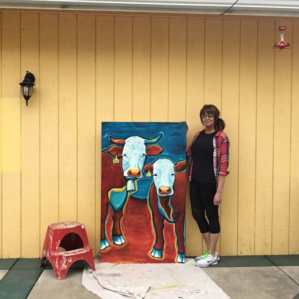 Artist Carrie Milburn (Snohomish, WA) next to her 5-foot tall cow painting, "Deja Moo".