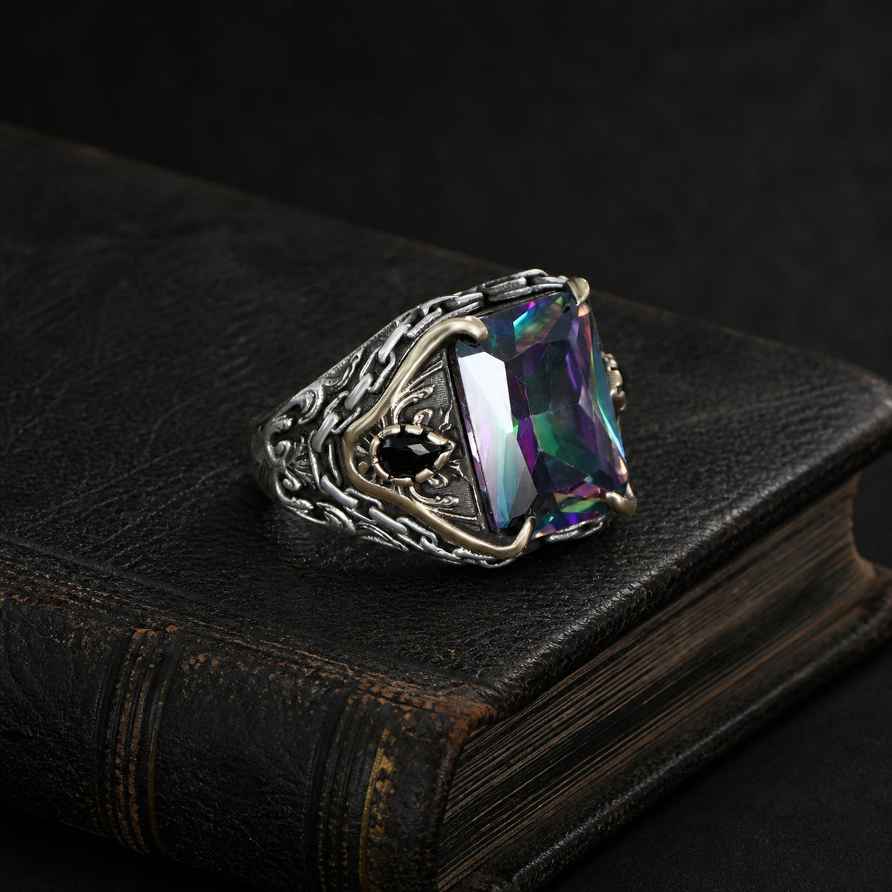 Mystic Topaz Chain Motif Sterling Silver Men's Ring displayed on a black leather antique book