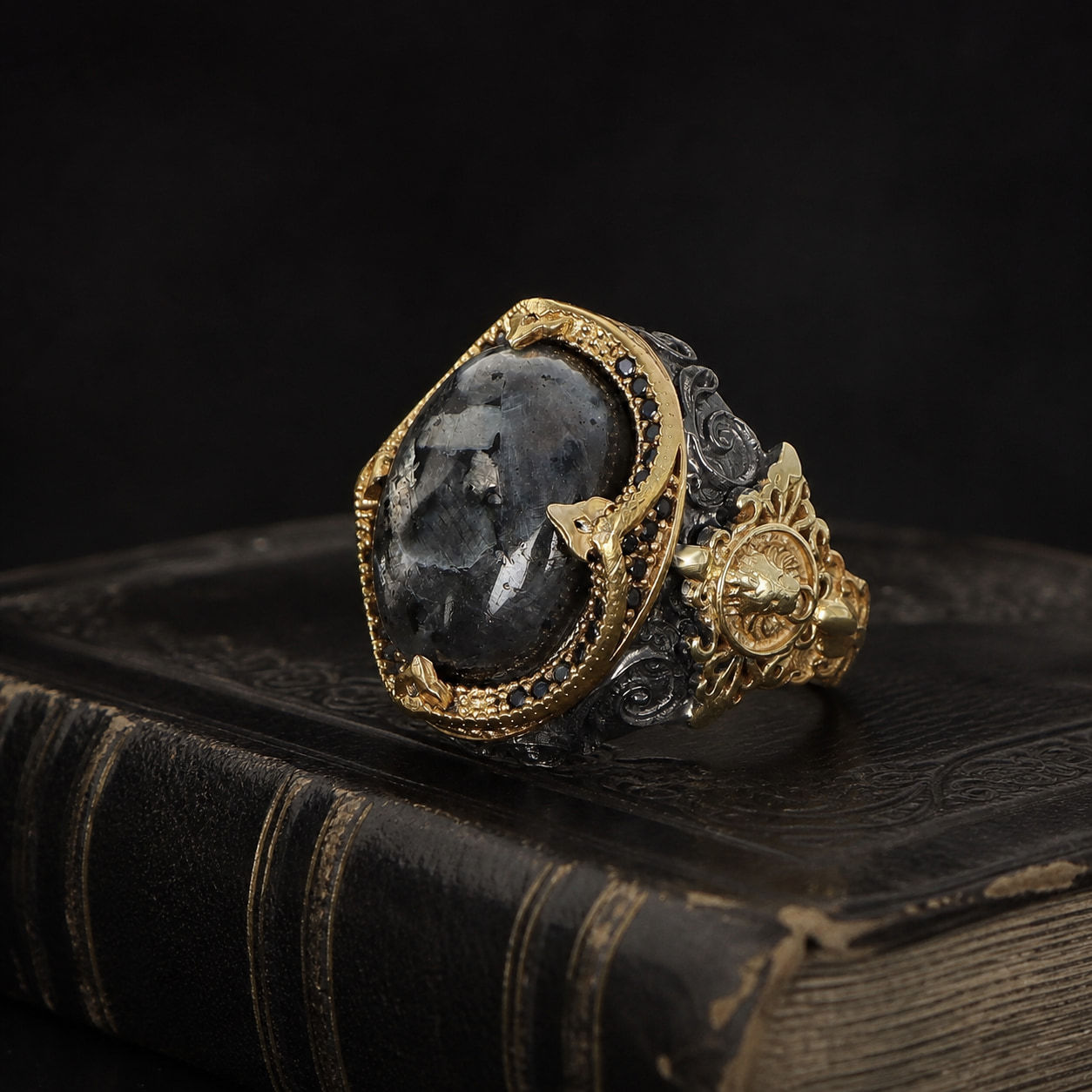 Larvikite Two Tone Sterling Silver Men's Ring on a black leather book