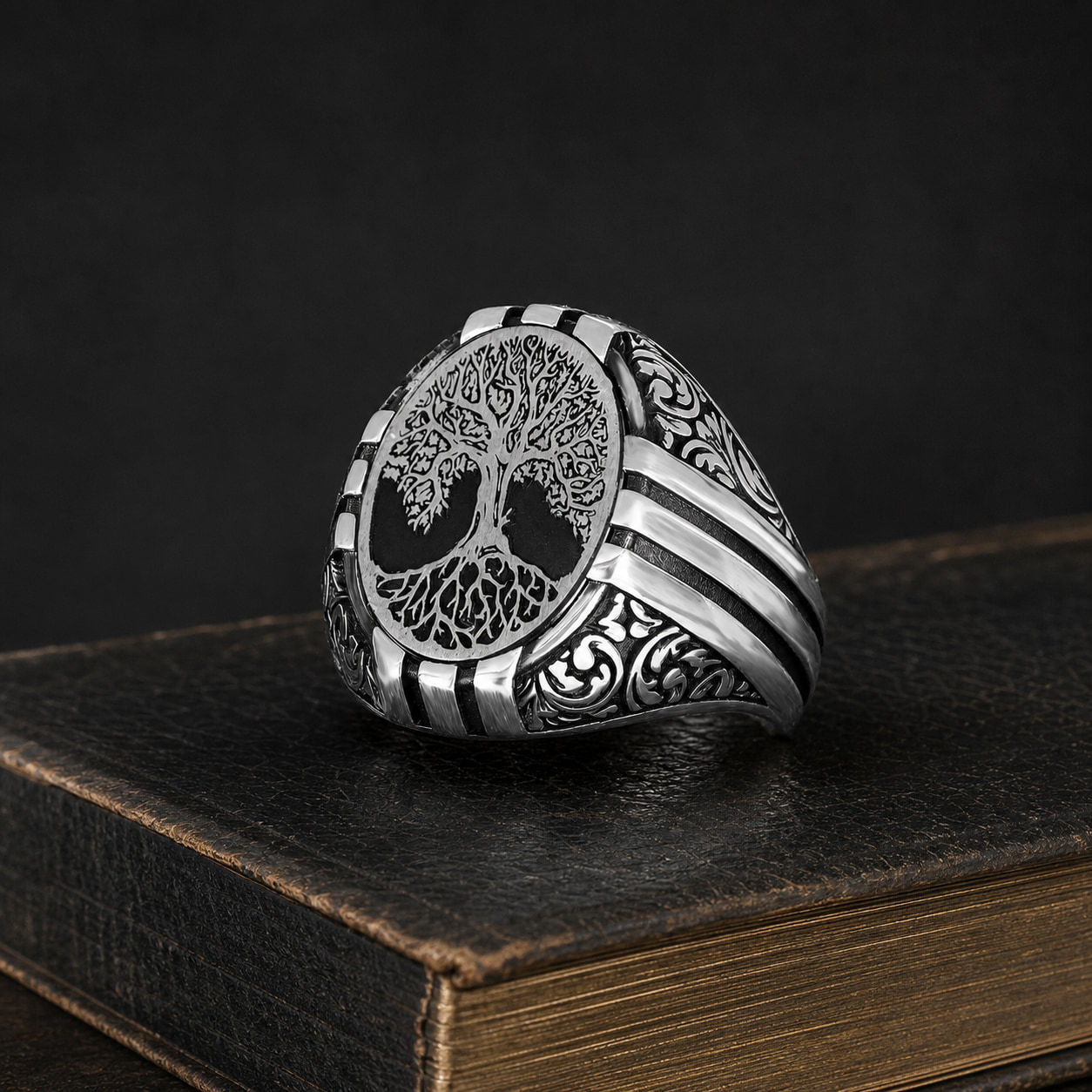Tree of Life Featherwork Sterling Silver Men's Ring on a black leather book