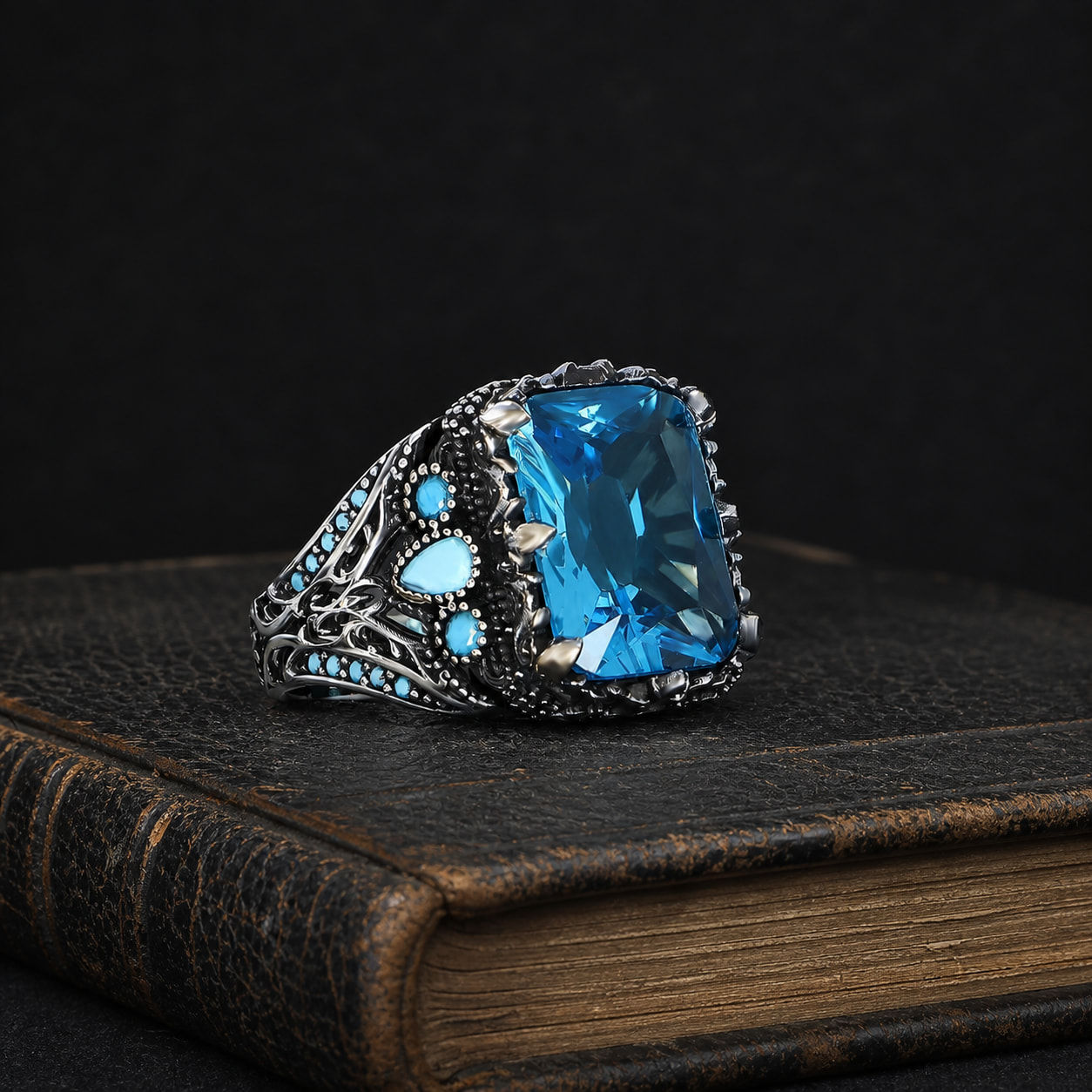 Ottoman Motif Rectangular Aqua Stone Men's Silver Ring on a black leather book