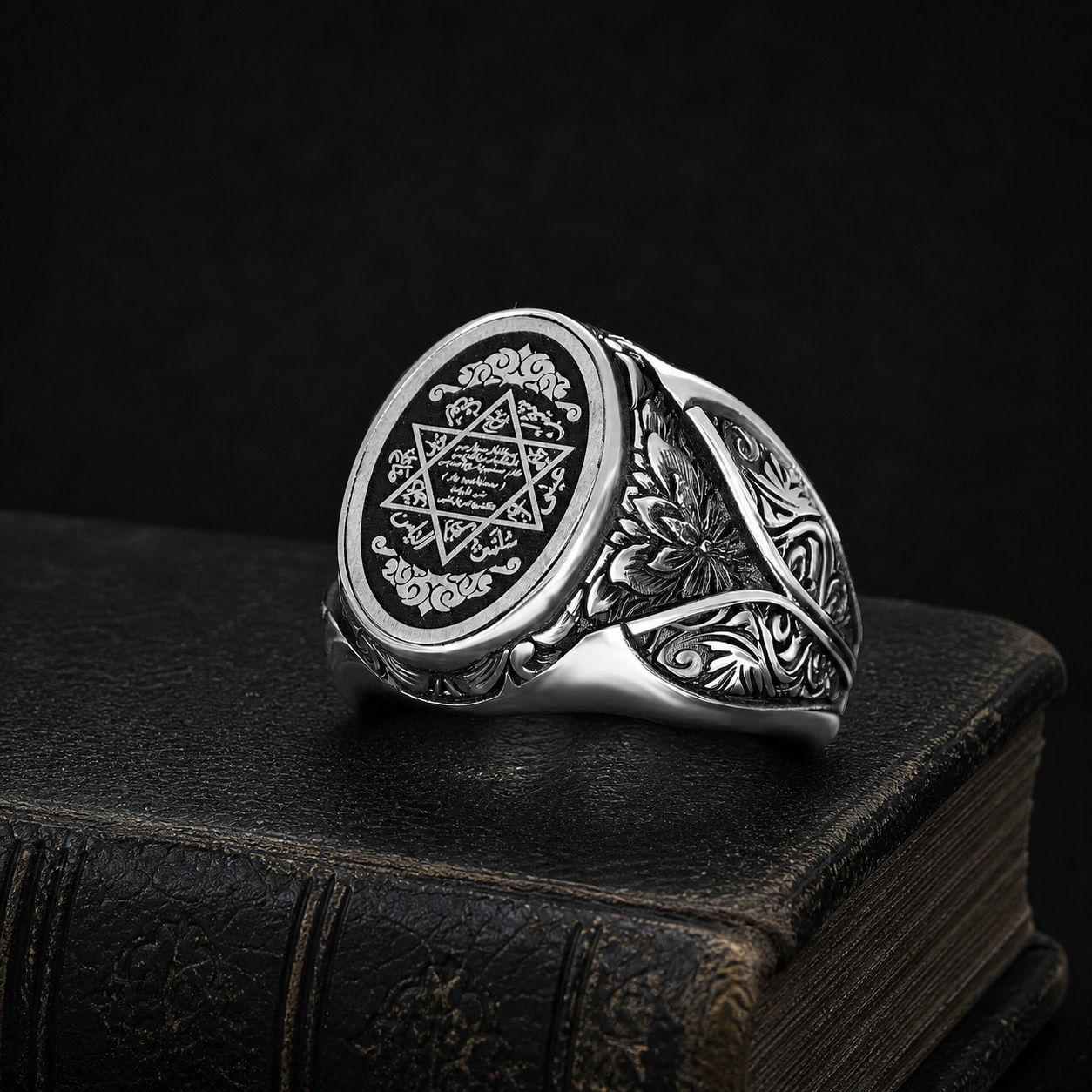 Seal of Solomon Black Featherwork Sterling Silver Men's Ring on a black leather book