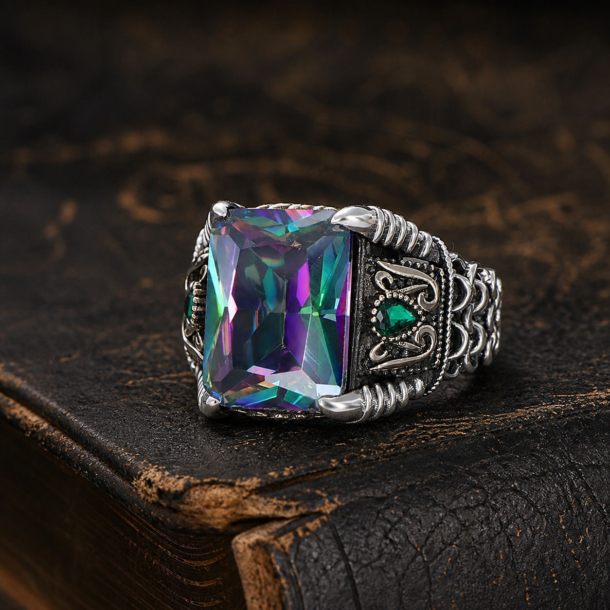 Rectangular Mystic Topaz Chain Sterling Silver Men's Ring displayed on a black leather antique book