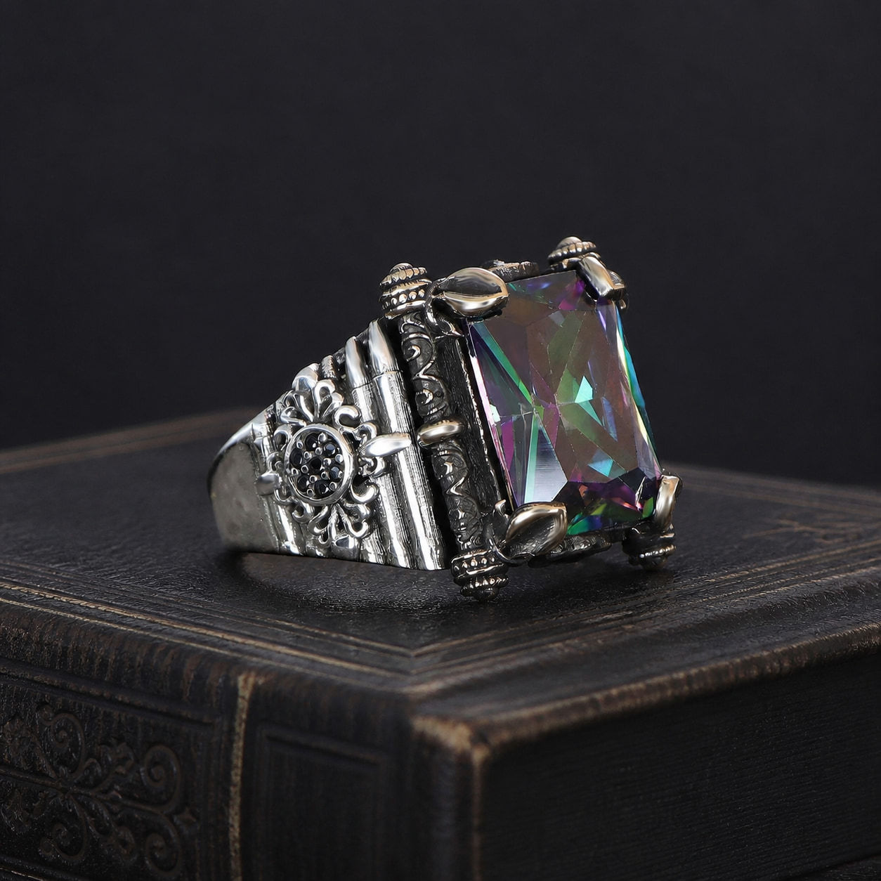 Mystic Topaz Architectural Sterling Silver Men's Ring on a black leather antique book
