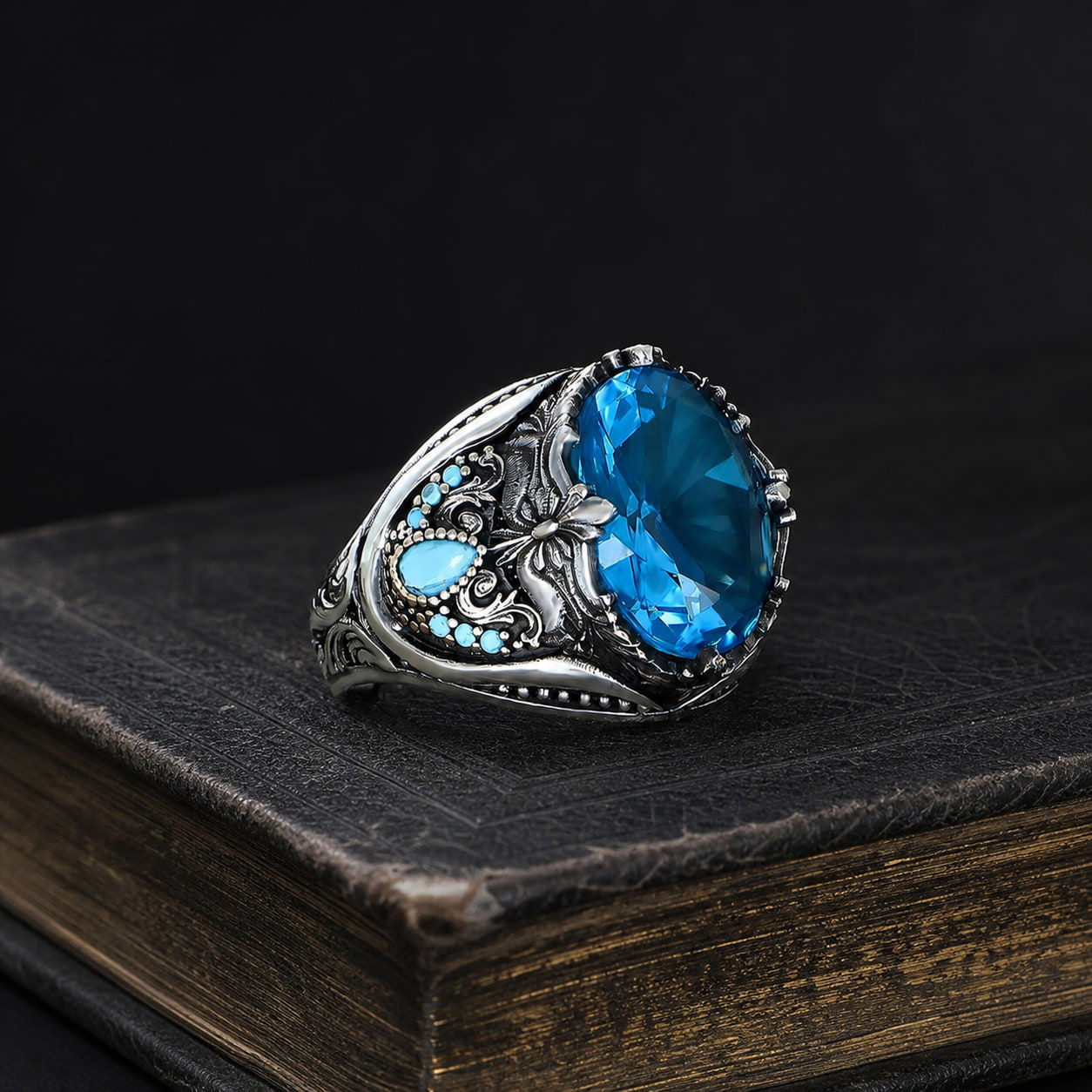 Aqua Blue Floral Sterling Silver Men's Ring on a black leather book