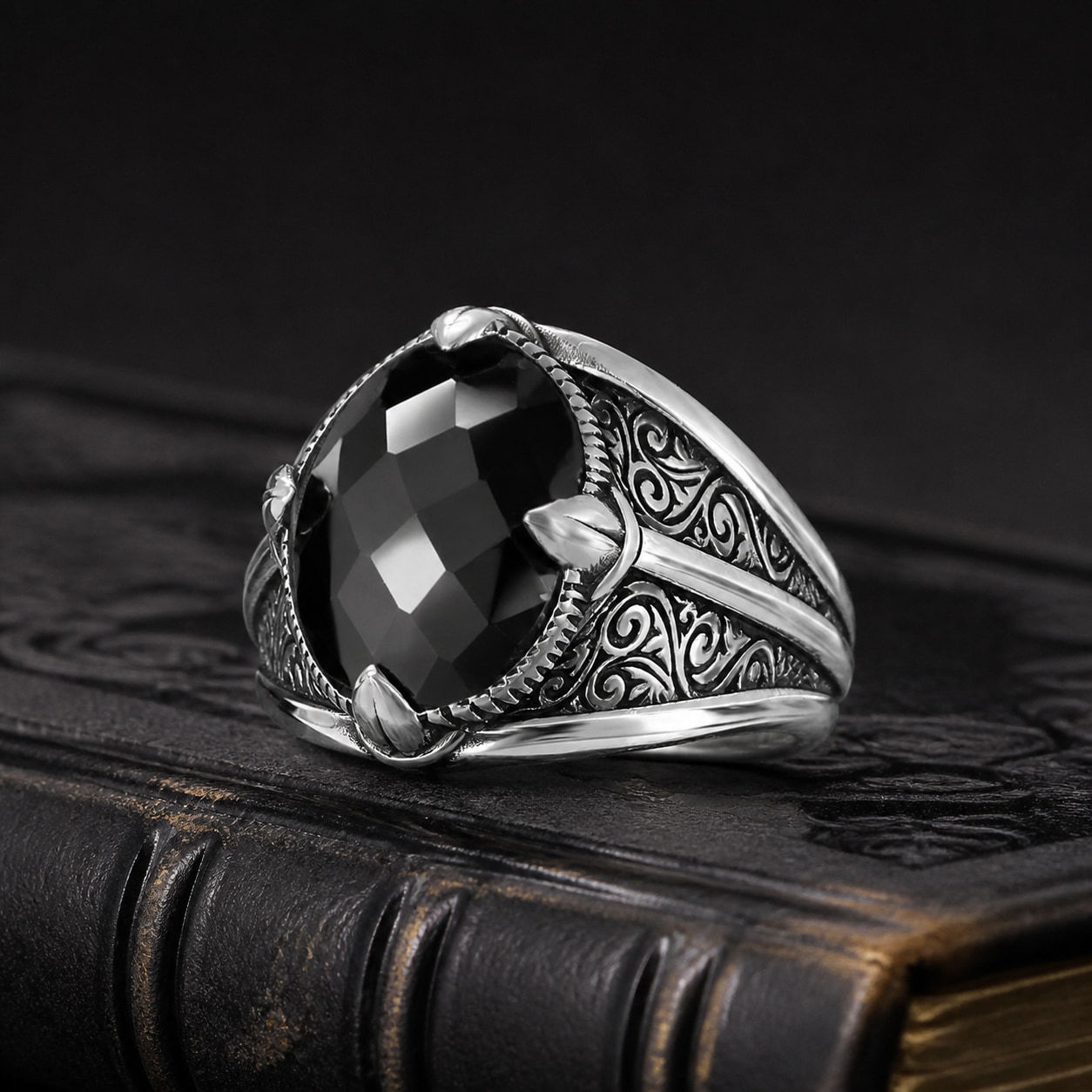 Faceted Black Zircon Sterling Silver Men's Ring on a black leather book