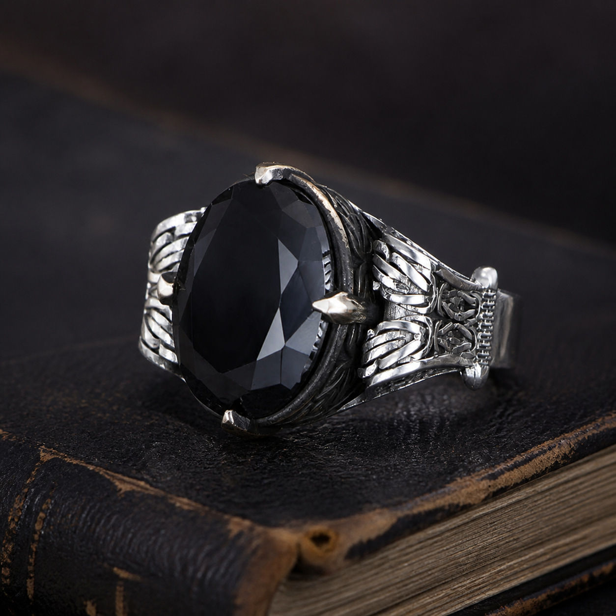 Black Zircon Oval Chain Motif Sterling Silver Men's Ring displayed on a black leather antique book