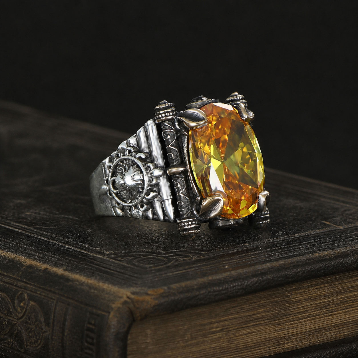 Citrine Wheel Emblem Sterling Silver Men's Ring on a black leather antique book