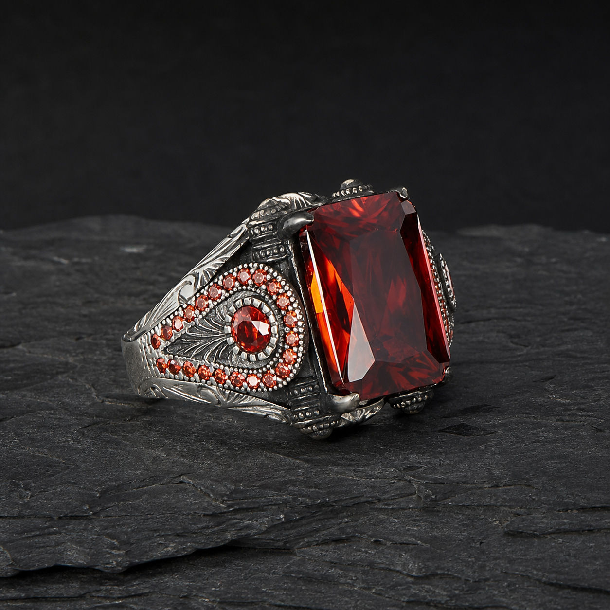 Red Zircon Triangular Motif Sterling Silver Men's Ring alternate view on a dark textured surface
