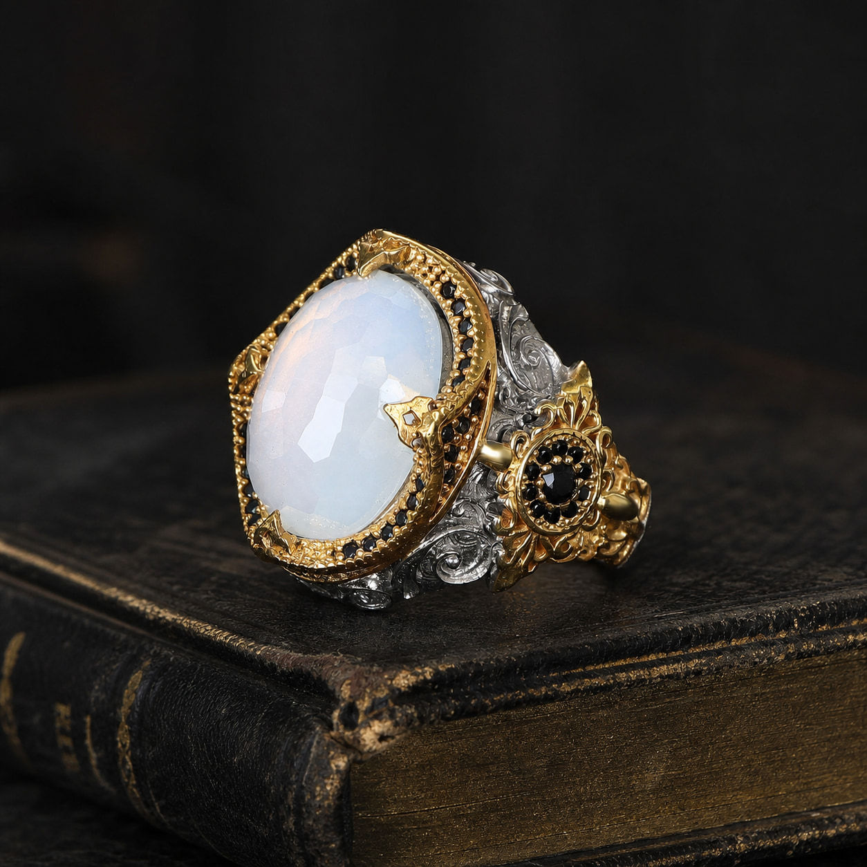 Moonstone Two Tone Sterling Silver Men's Ring on a black leather book