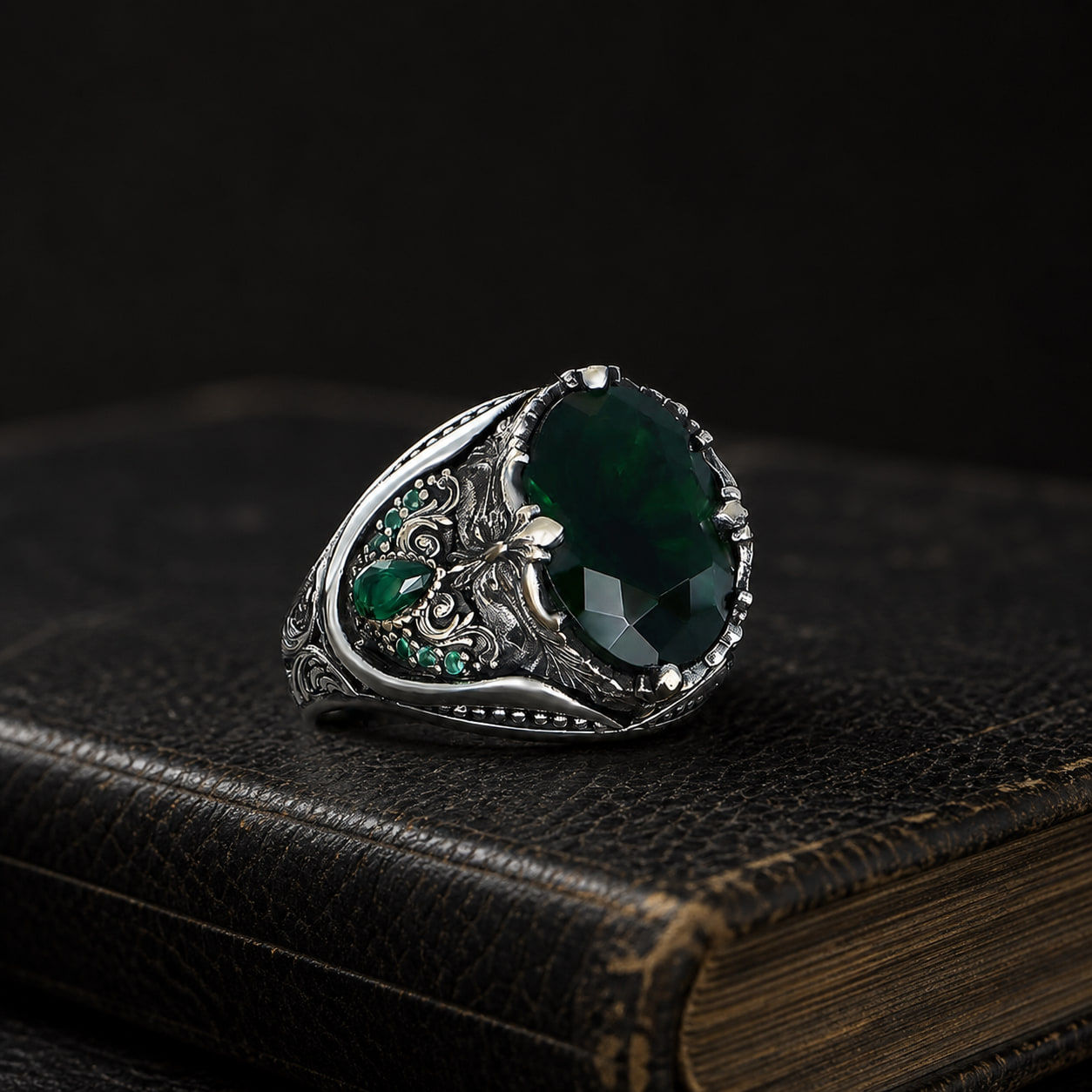 Green Zircon Floral Sterling Silver Men's Ring on a black leather book