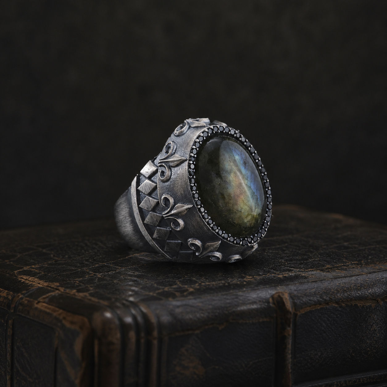 Natural Labradorite Geometric Sterling Silver Men's Ring on a black leather antique book