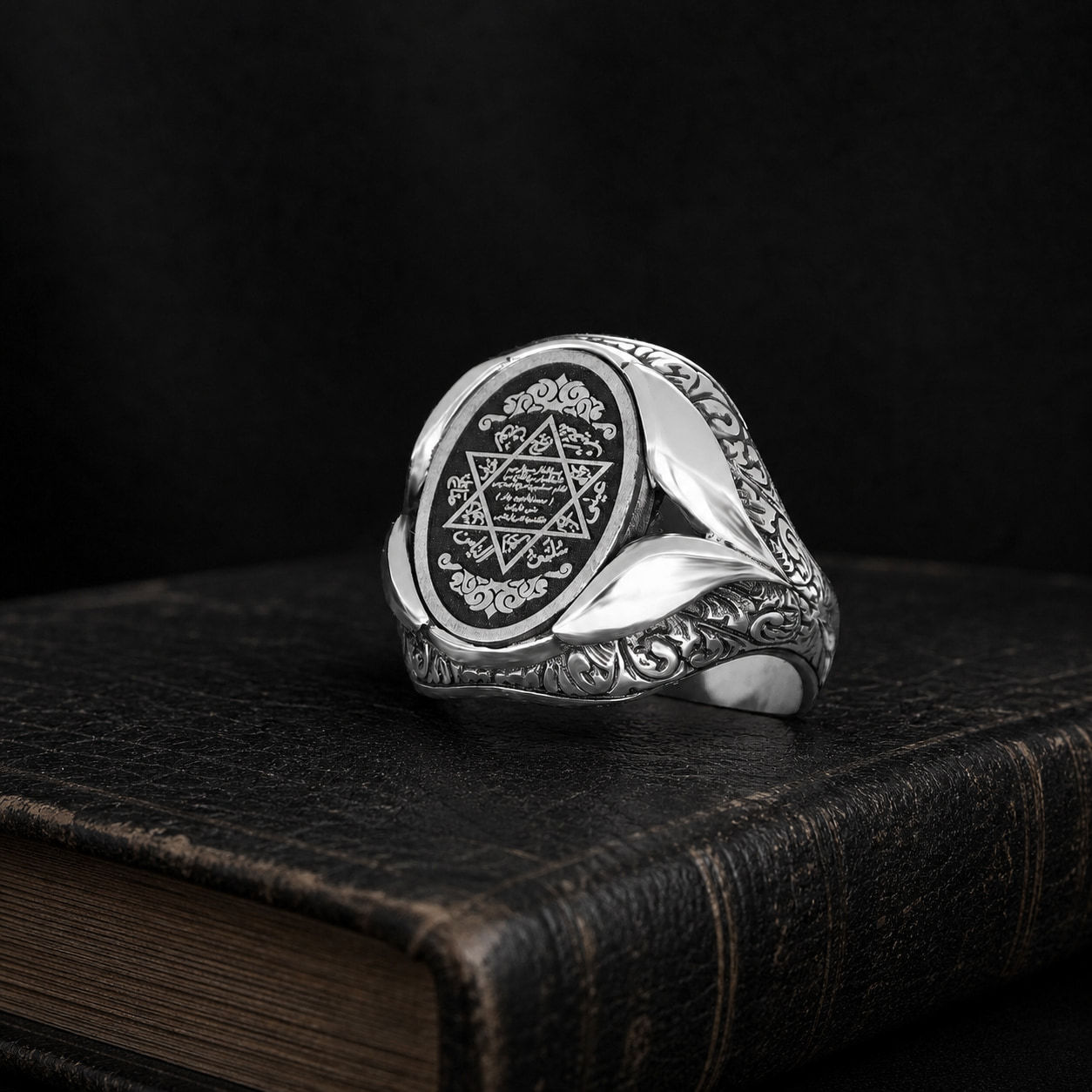 Seal of Solomon Dark Medallion Sterling Silver Men's Ring on a black leather book