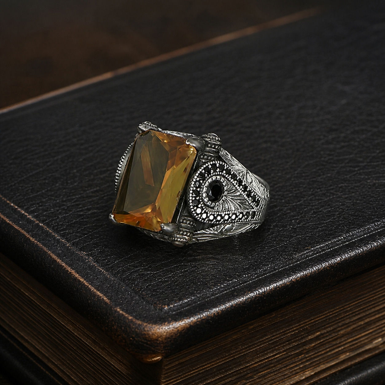 Zultanite Triangular Motif Sterling Silver Men's Ring displayed on a black leather antique book