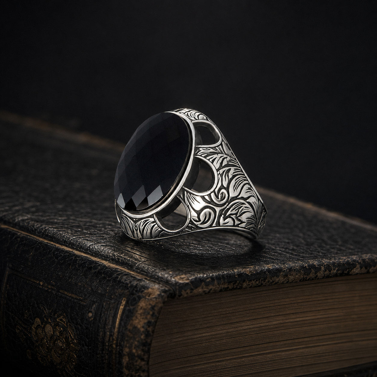 Black Zircon Botanical Sterling Silver Men's Ring on a black leather book