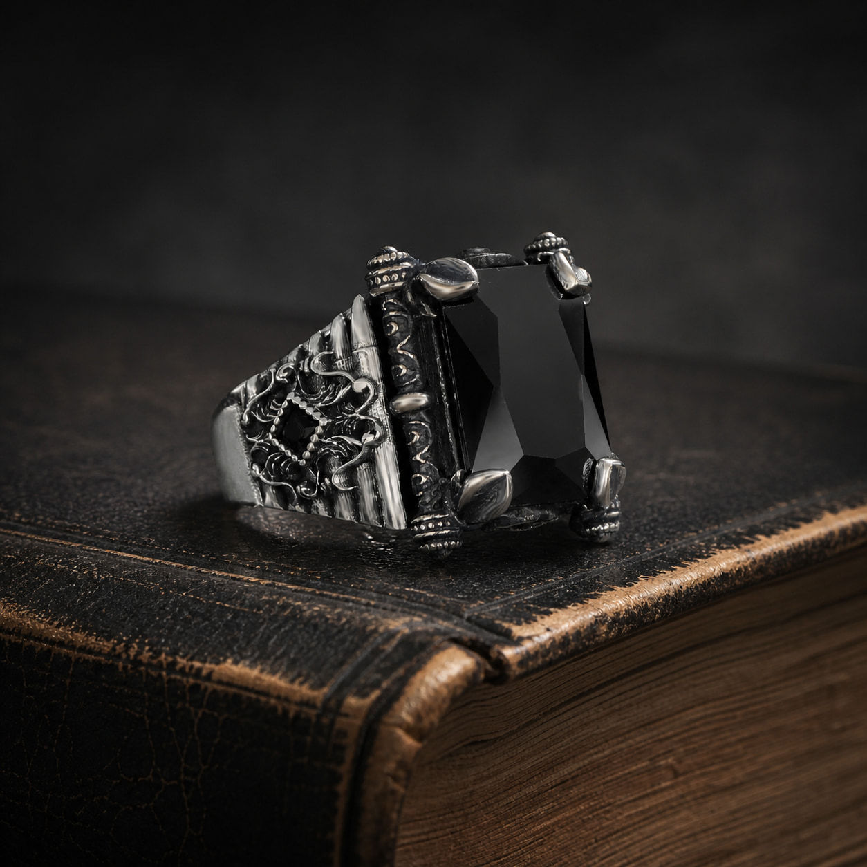 Black Zircon Openwork Sterling Silver Men's Ring displayed on a black leather antique book