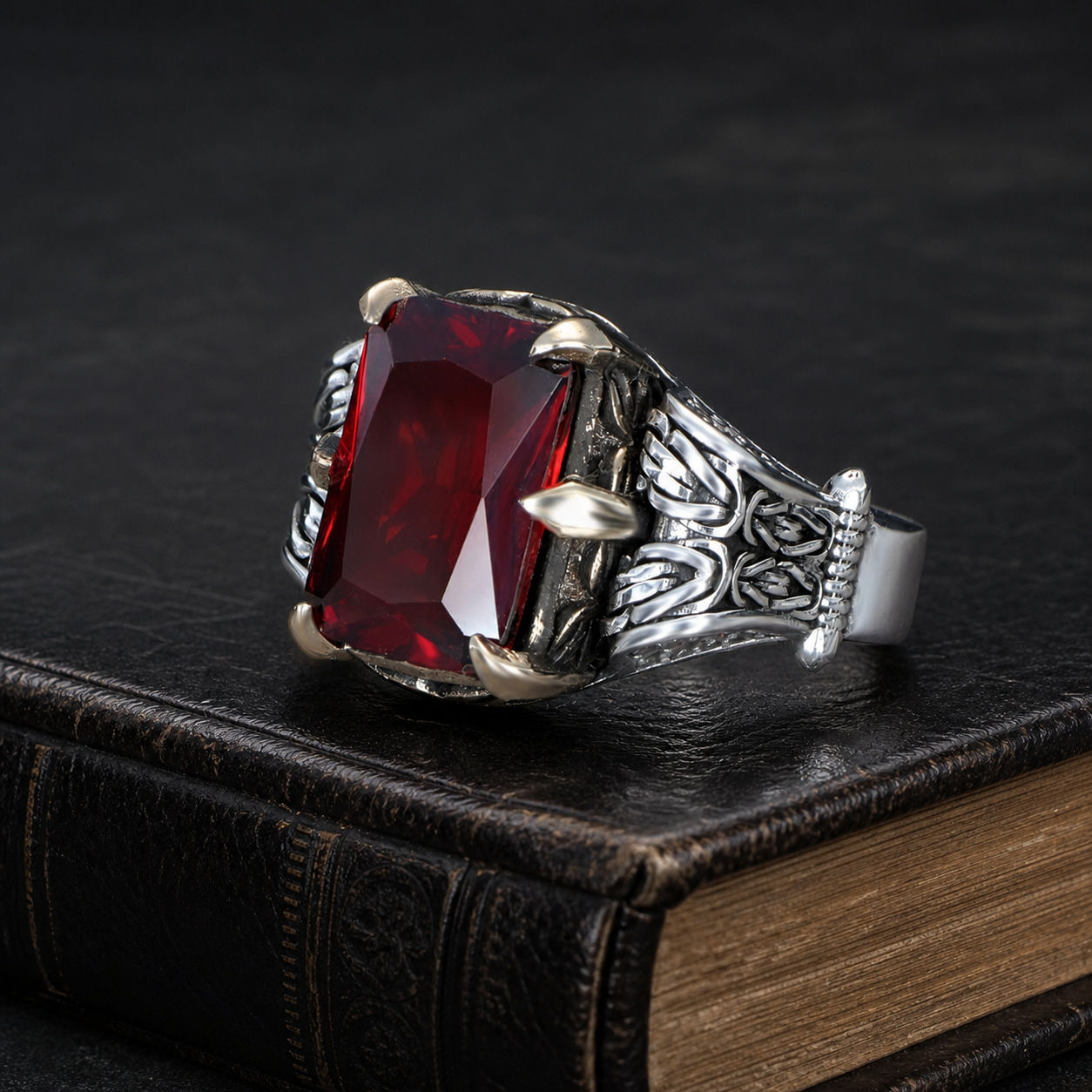 Red Zircon Chain Motif Sterling Silver Men's Ring displayed on a black leather antique book