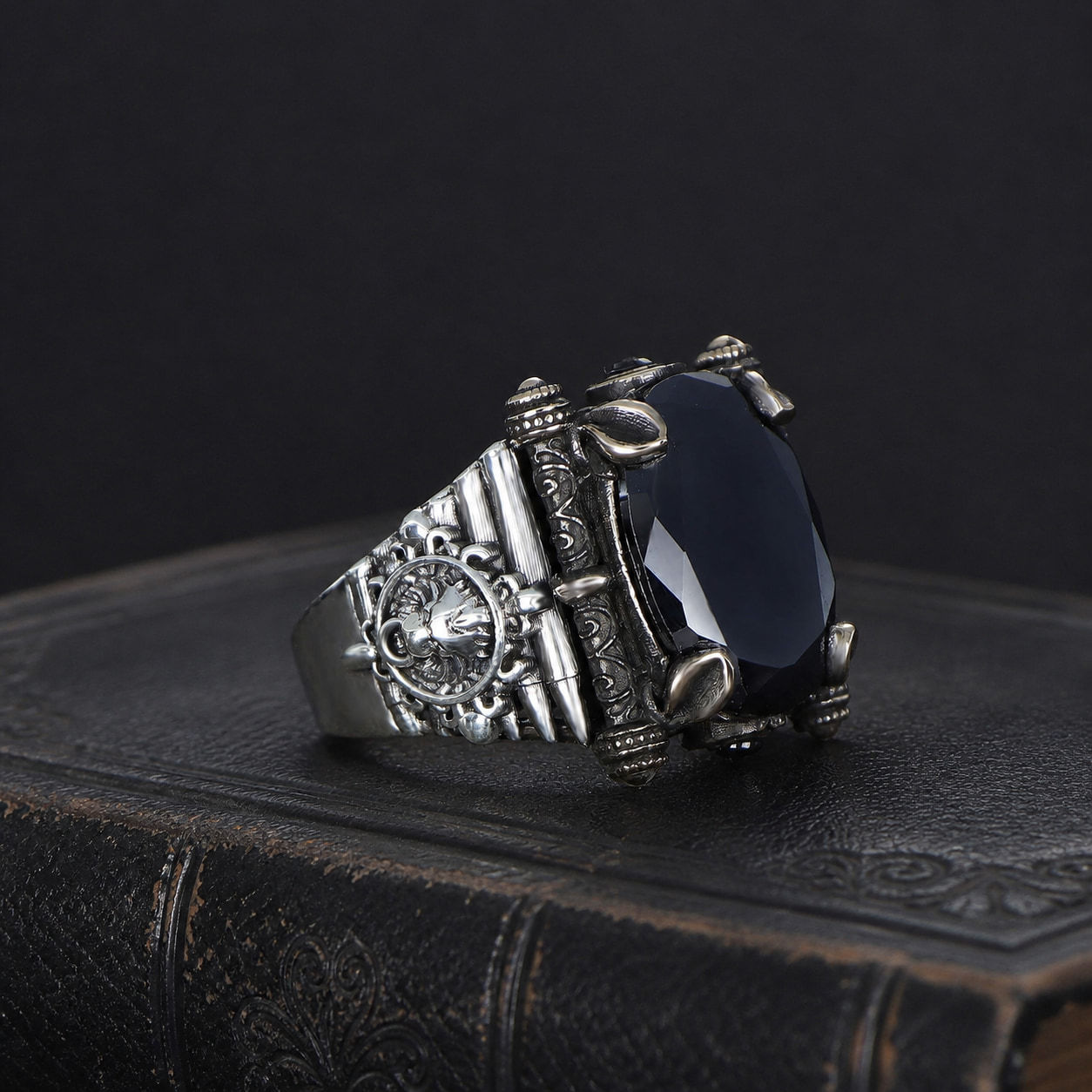 Black Zircon Wheel Emblem Sterling Silver Men's Ring on a black leather antique book