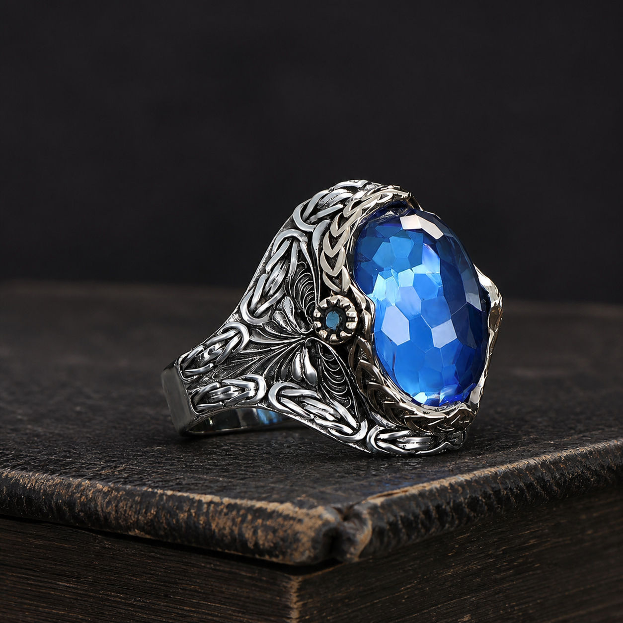 Blue Topaz Floral Sterling Silver Men's Ring displayed on a black leather antique book