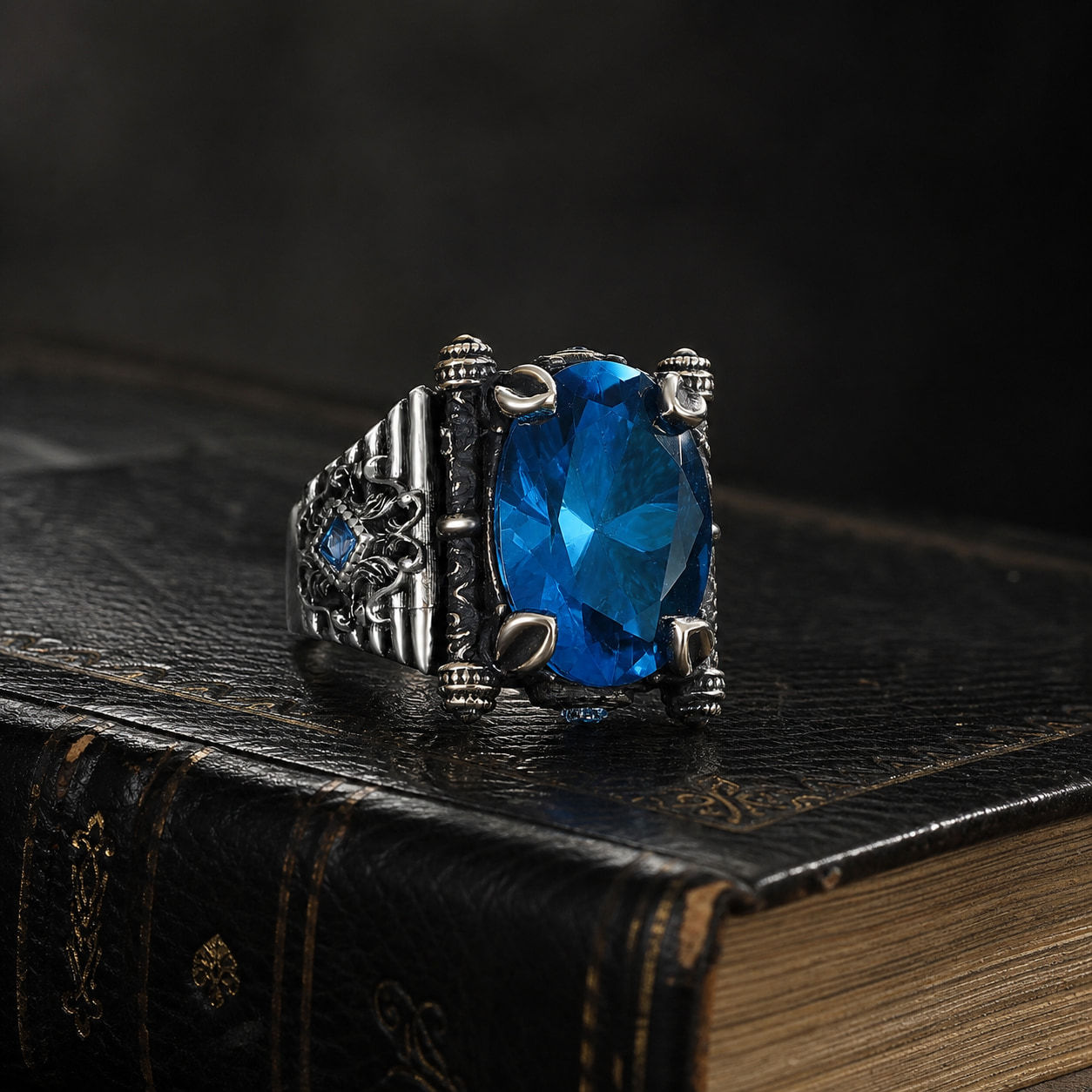 Aquamarine Floral Sterling Silver Men's Ring displayed on a black leather antique book