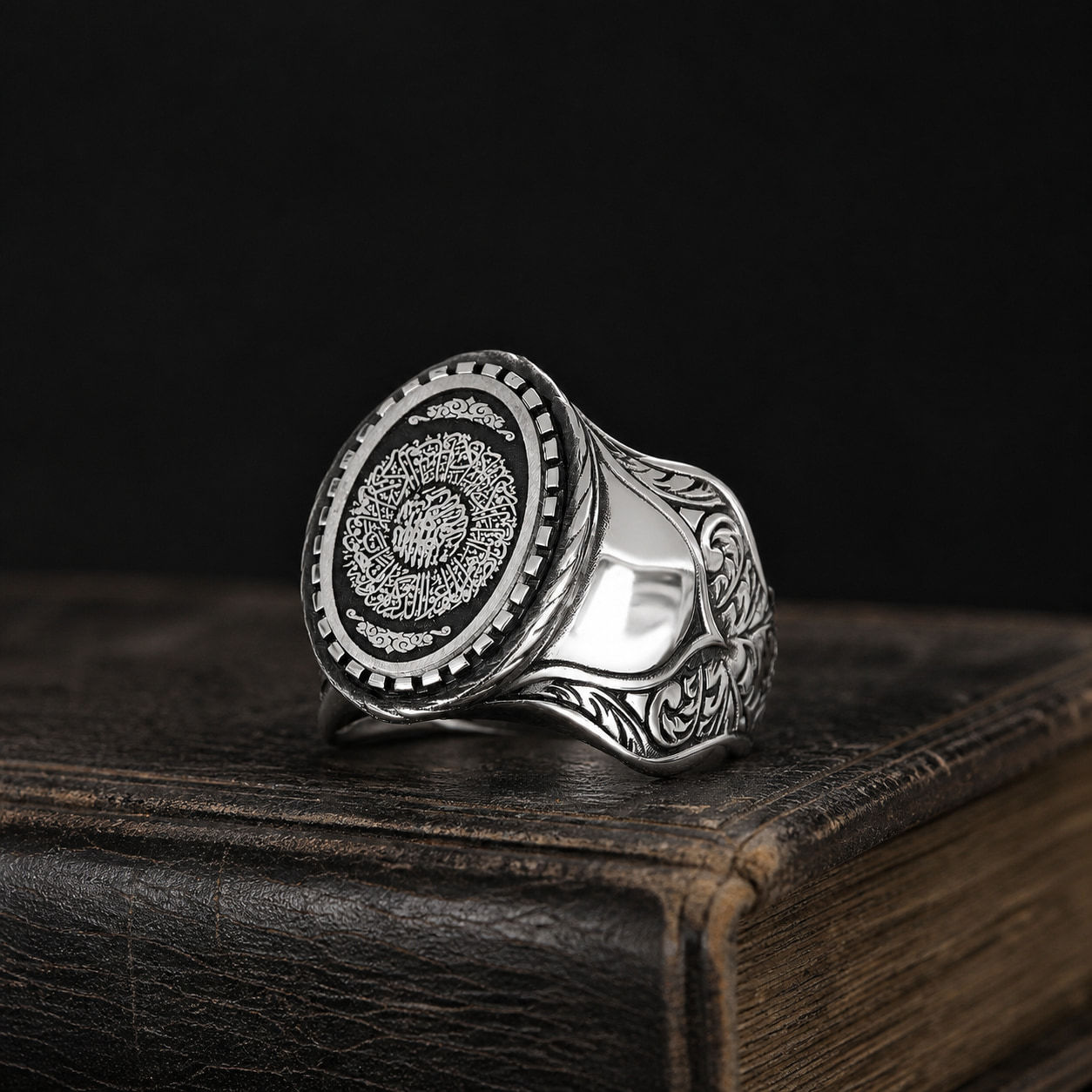Surah Ash Sharh Openwork Sterling Silver Men's Ring on a black leather book