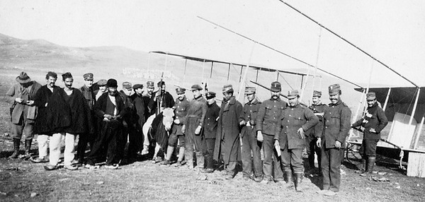 Το αεροδρομίου Νικόπολης προς τα βορειοανατολικά. Μπροστά από τα δύο αεροπλάνα προσωπικό του Στρατού, ένας αξιωματικός του Ναυτικού, ντόπιοι βοσκοί και Γάλλοι μηχανικοί. Φωτογραφία του Etienne Labranche, Δεκέμβριος 1912 (Φωτογραφικό Αρχείο Ιδρύματος Ακτία Νικόπολις, ΙΑΝ F2334, δημοσιευμένη στο άρθρο «Ιπτάμενοι στη Νικόπολη: Η δράση του Λόχου Αεροπορίας στην Ήπειρο κατά τον Α ́ Βαλκανικό πόλεμο (1912-1913)» James S. Curlin, Πρεβεζάνικα Χρονικά Αρ. 49-50, 2013)