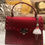 Thumbnail: Red and white doll purse charm keychain displayed on red messenger handbag.