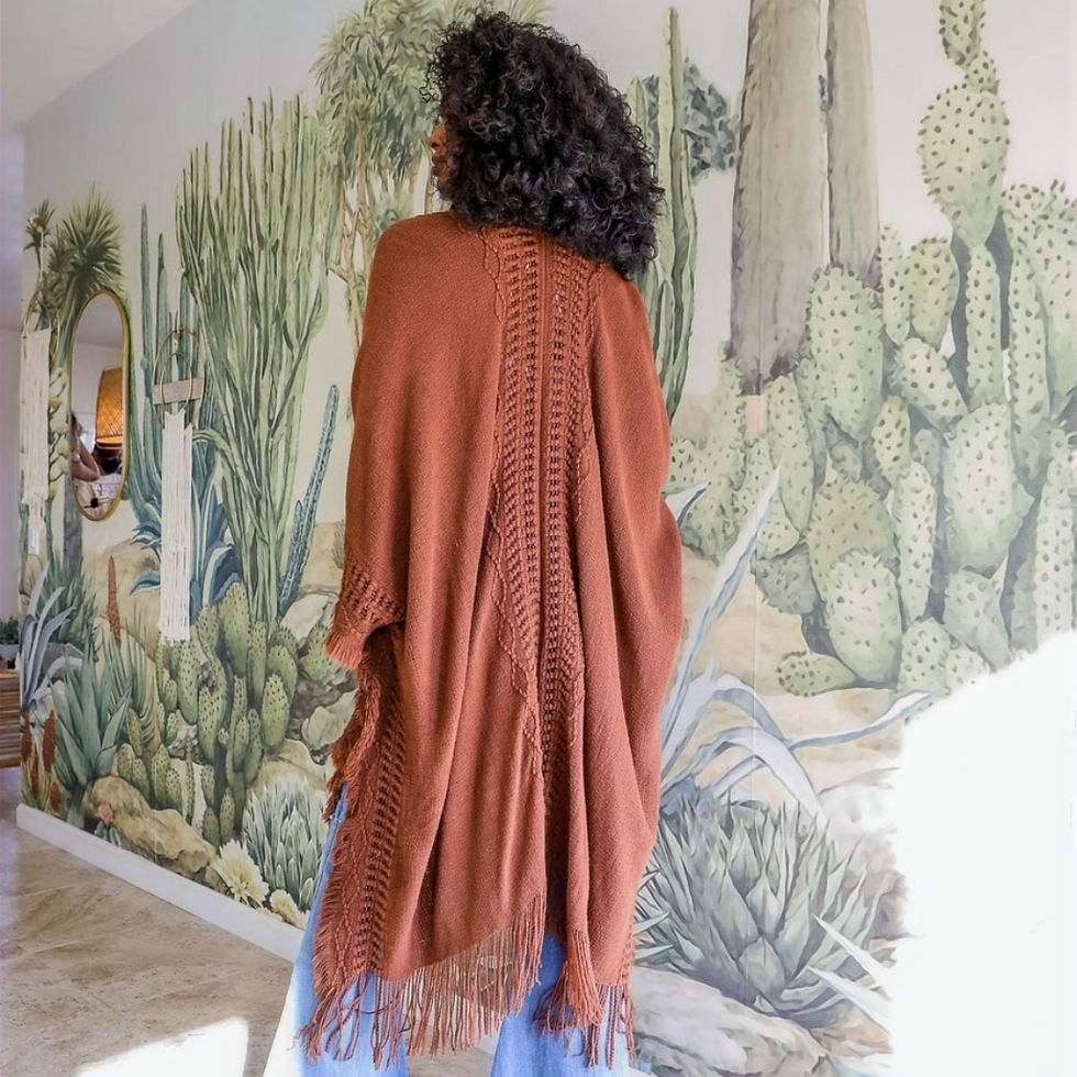 Back-side view rust fringe ruana with frayed edges displayed draped on model, perfect for layering