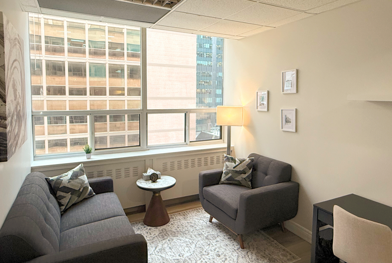 Treatment room with a couch, chair, and desk