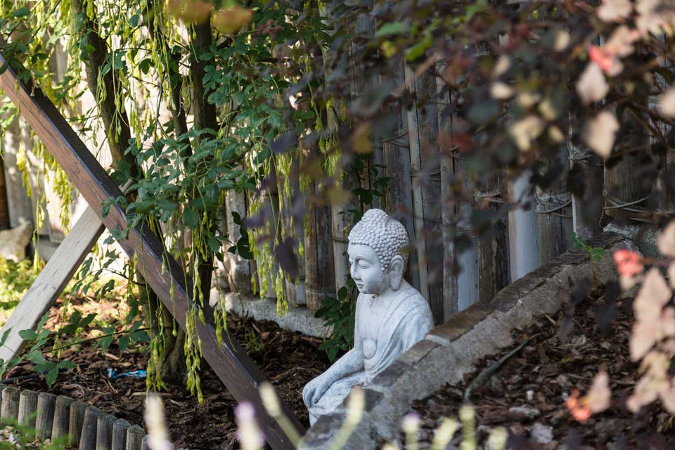 eine buddha-statue aus stein im beschatteten garten