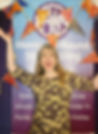 Amanda Kane-Smith smiling infront of her event banner for Merry-go-Round Storytelling.jpg