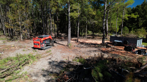Kubota Skid Steer cleaning up trees and debris
