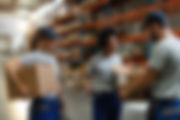 happy-african-american-woman-her-coworkers-examining-packages-while-working-distribution-w