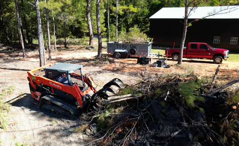 Kubota Skid Steer cleaning up trees and debris
