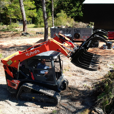 Kubota Skid Steer cleaning up trees and debris