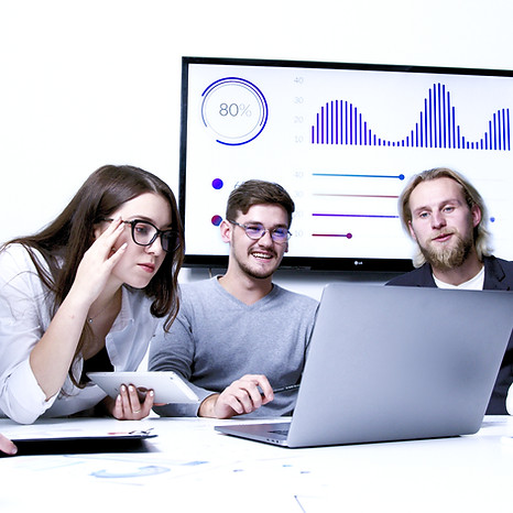 alt=" employees in a workplace looking and working on a laptop"