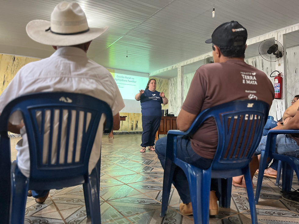 Agricultoras e agricultores escutam palestra sobre planejamento rural.