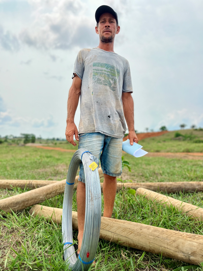 Agricultor com arame e estacas.