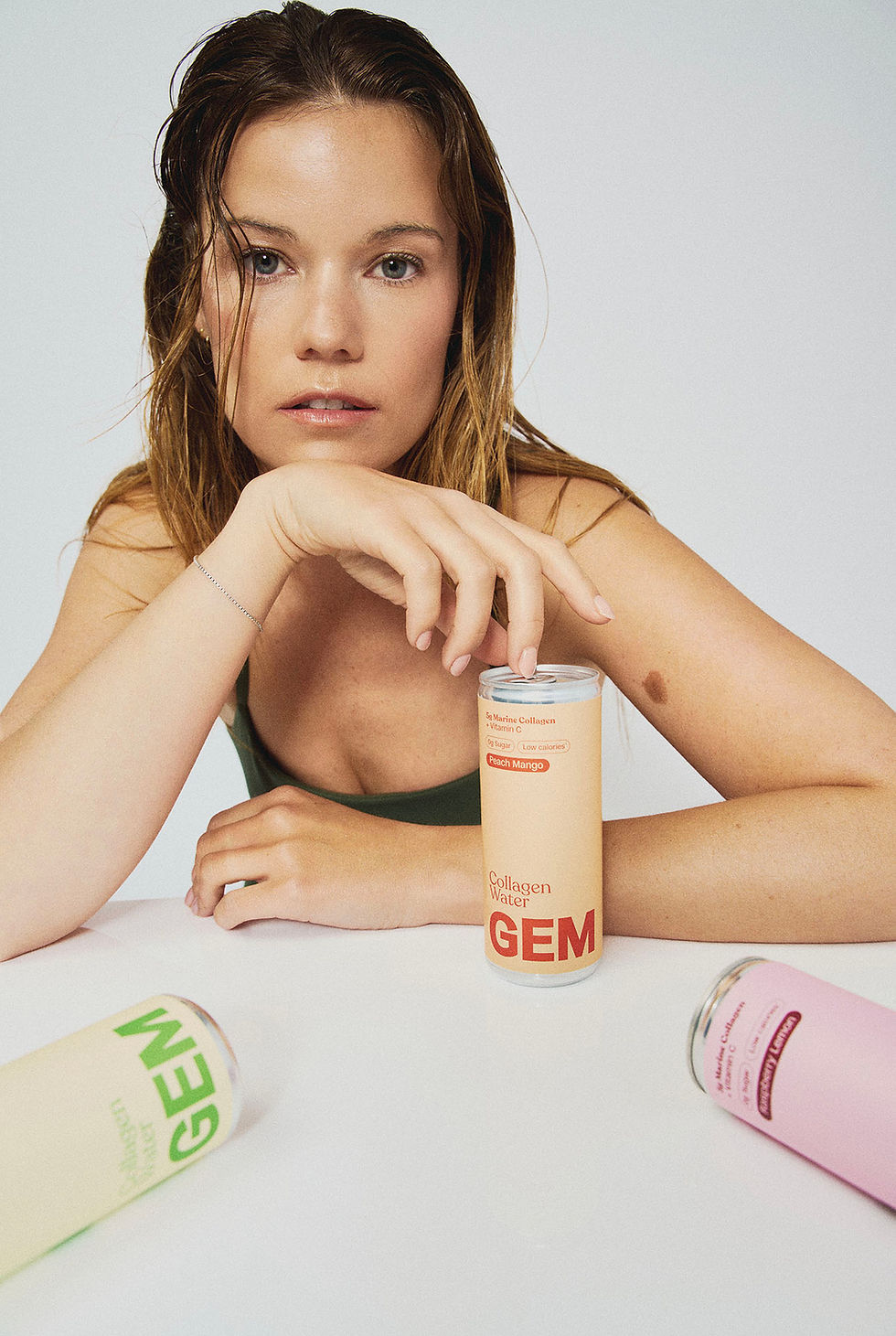 young woman wet look hair with GEM collagen drinks cans