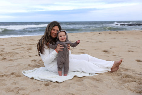 mom and baby on a blanket on the beach