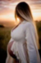 pregnant mother turned away from camera looking at sunset