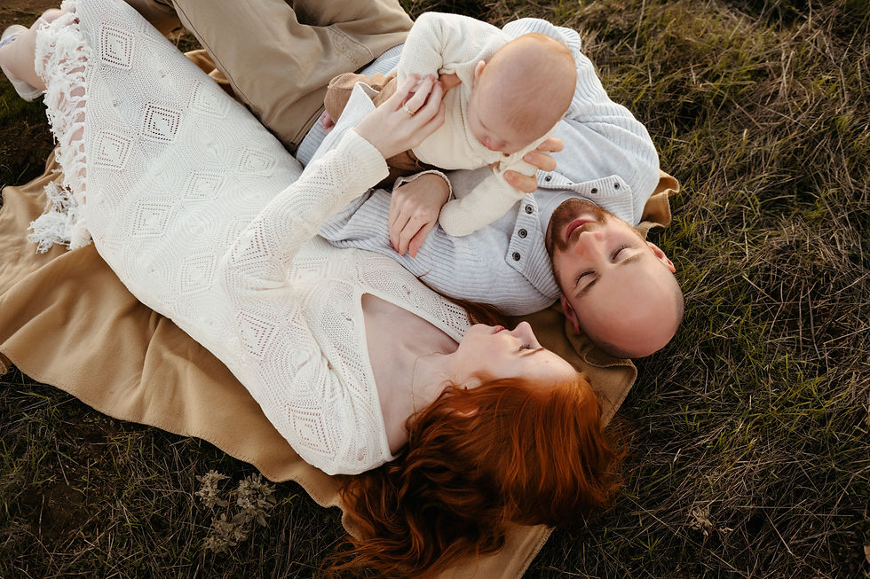 couple laying down and looking at their baby boy