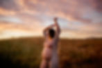 pregnant mother holding her hands up during sunset maternity session in a regional park in Petaluma