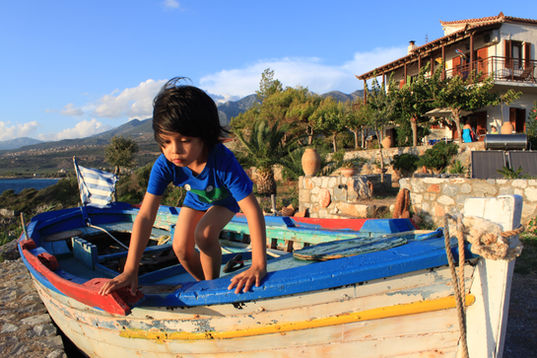 Young Yogi Fraisl playing on a boat in Mani, Greece